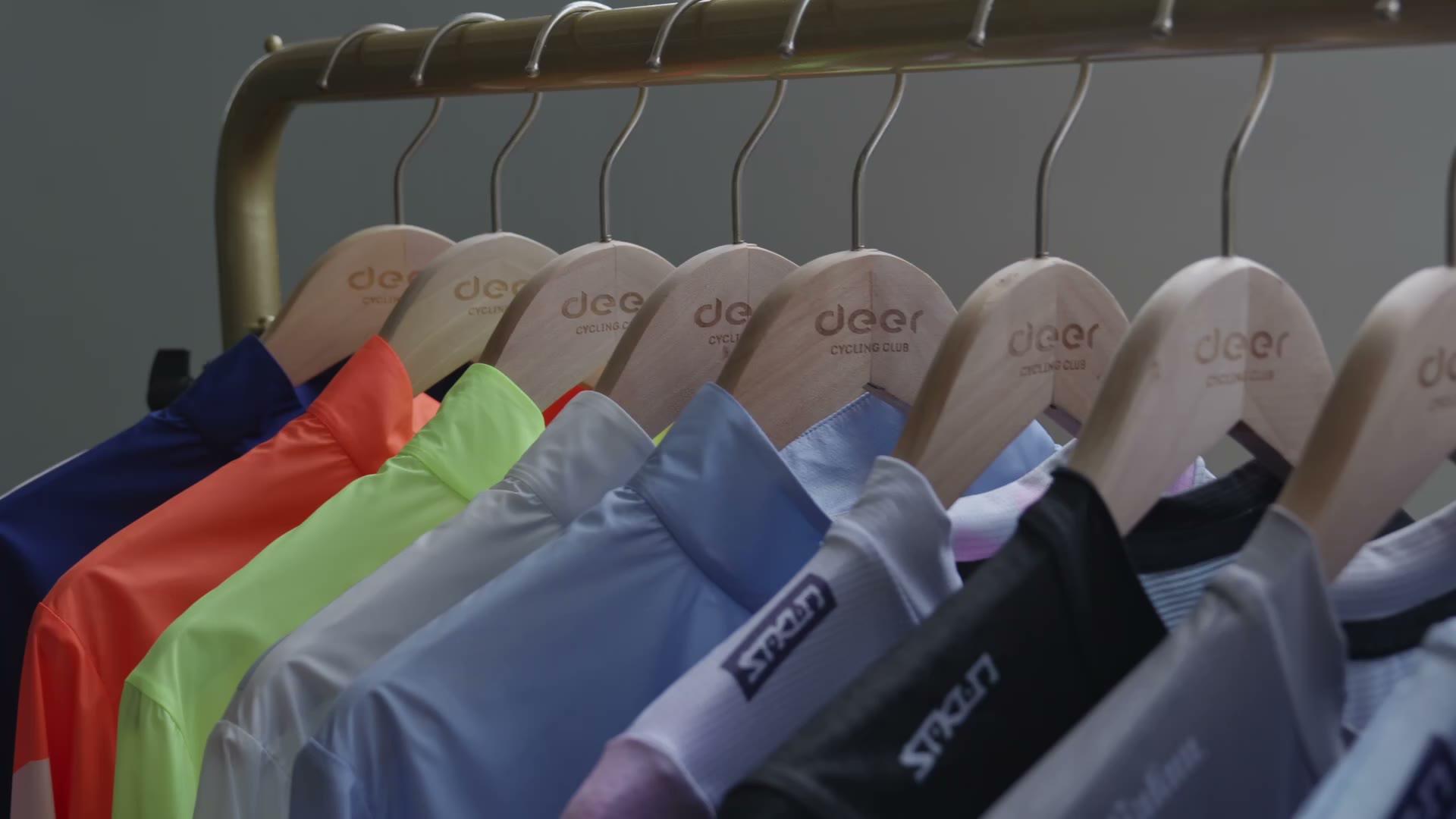 Cycling jerseys arranged on a garment rack.
