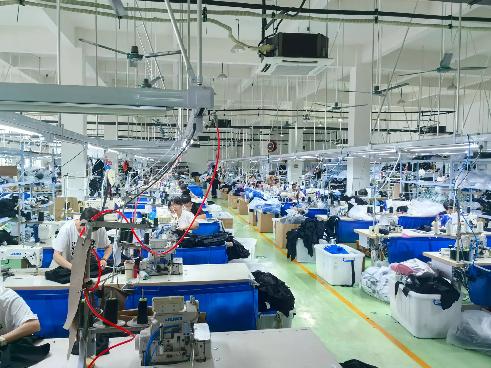Production/process context showing sewing workstations and garment work.