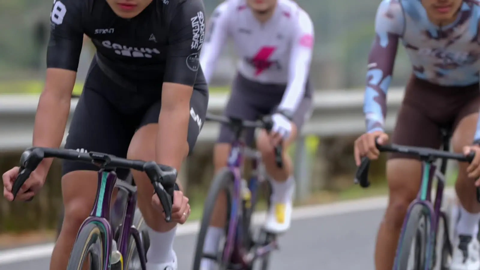 Cyclists riding in cycling apparel on a road.