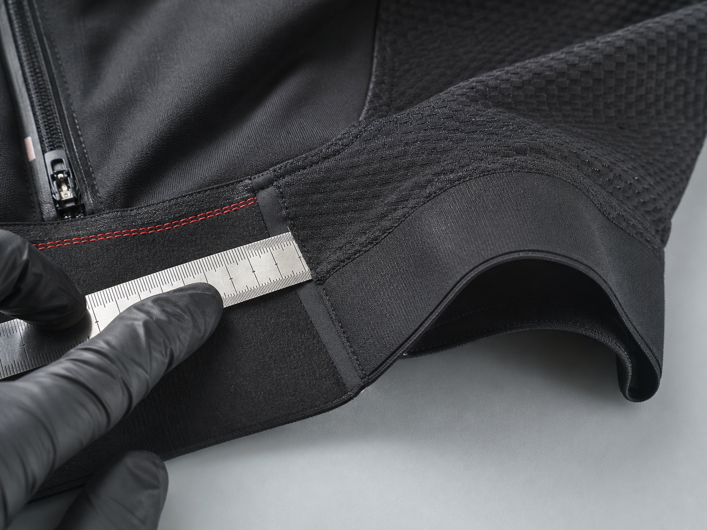 Illustrative macro inspection of technical fabric, zipper termination, panel junction, and seam alignment